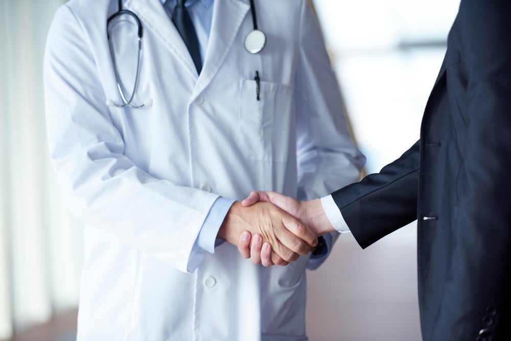 doctor handshake with a patient at doctors bright modern office in hospital doctor handshake with a patient at doctors bright modern office in hospital